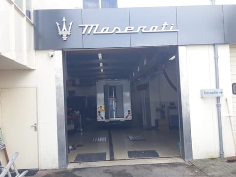 De entree met het Maserati logo boven de deur