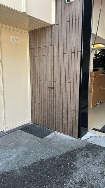 Detail van de bamboe gevelbekleding met de verborgen toegangsdeur